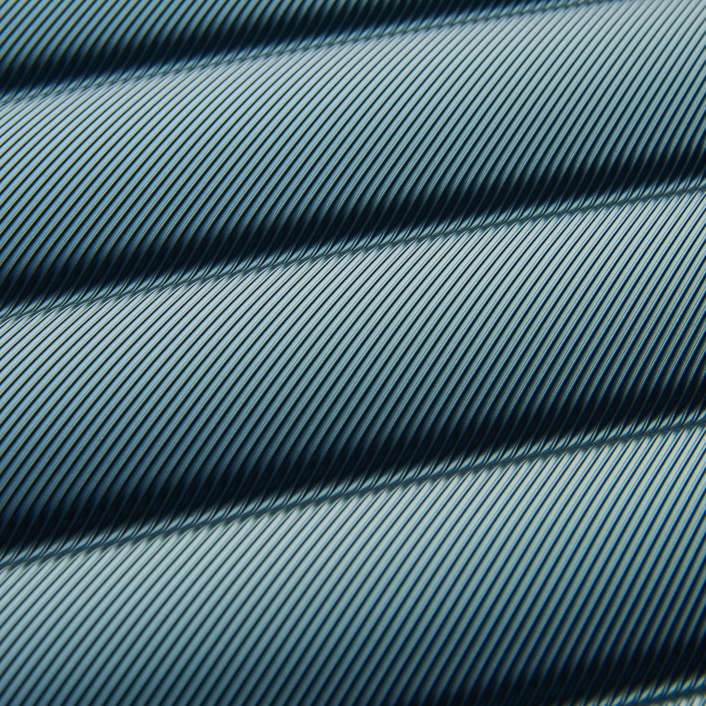 Detalhe da textura rígida com linhas diagonais finas em tom verde escuro, característica de malas DELSEY premium, destacando durabilidade e design inovador.