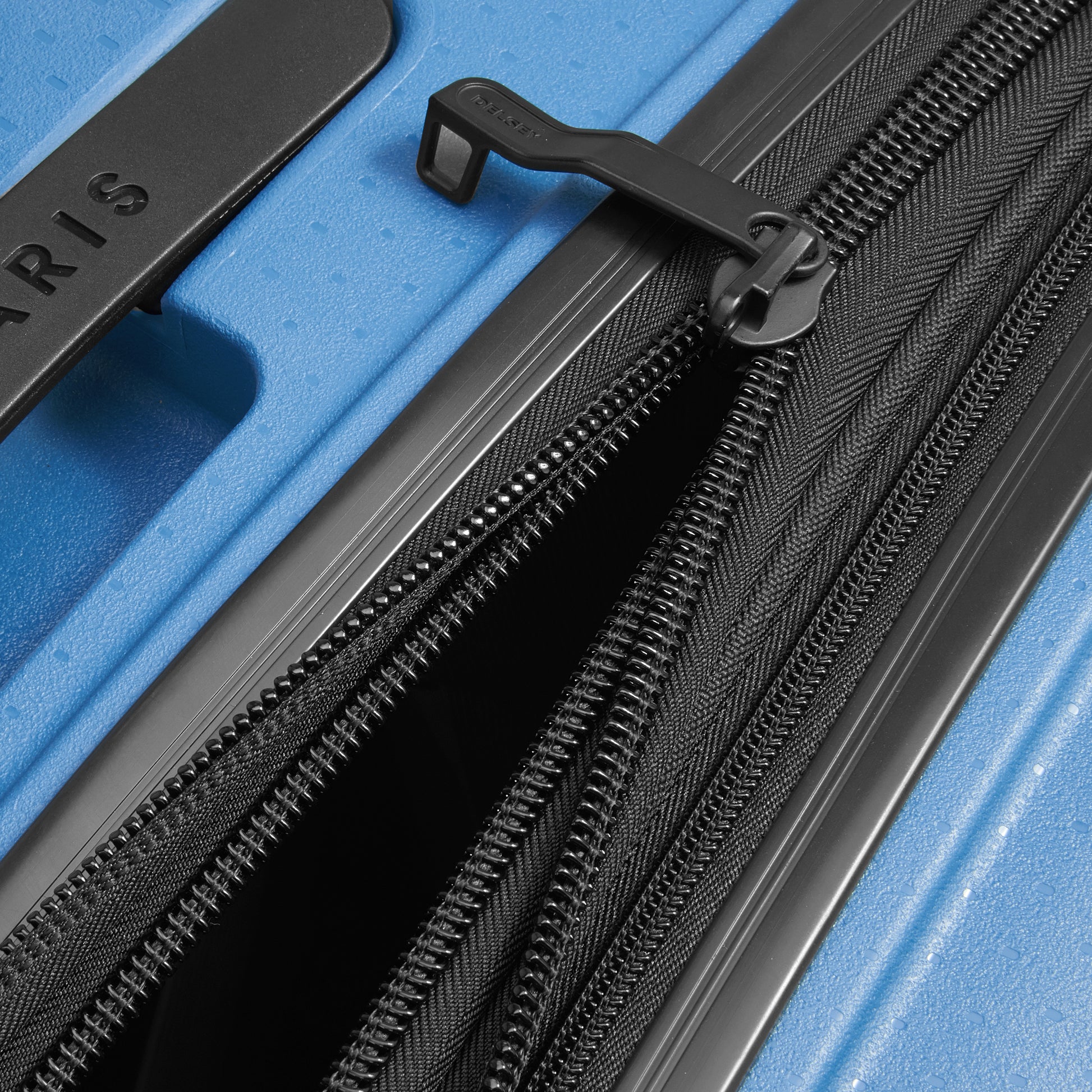 Fechamento com zíper expansível em mala de bordo azul intenso da DELSEY, destacando durabilidade e design inovador para viagens.