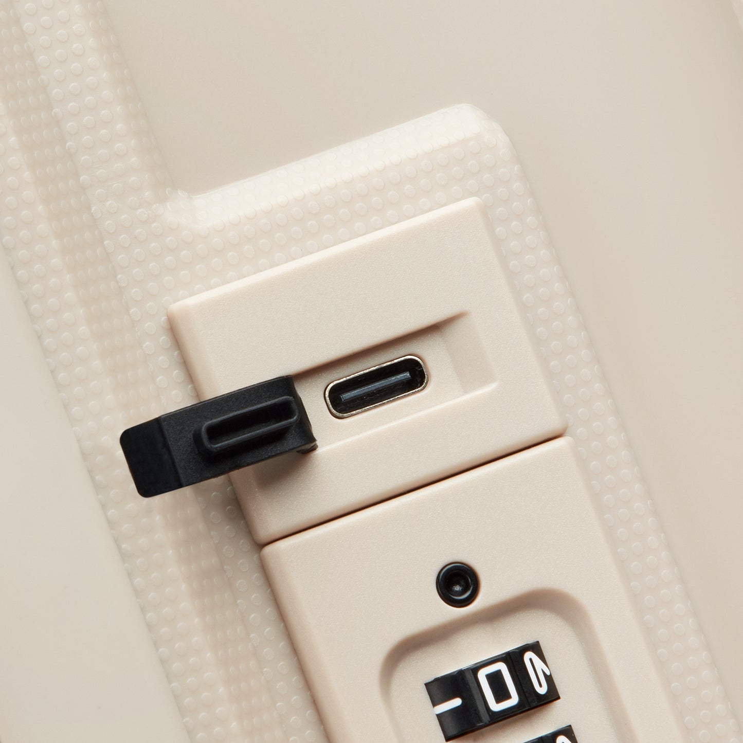 Fechadura com combinação segura e entrada USB protegida por tampa, em acabamento bege, parte da mala de bordo expansível da DELSEY, garantindo proteção e funcionalidade.