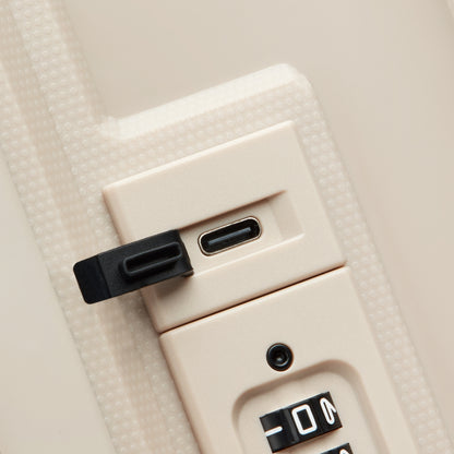 Fechadura com combinação segura e entrada USB protegida por tampa, em acabamento bege, parte da mala de bordo expansível da DELSEY, garantindo proteção e funcionalidade.