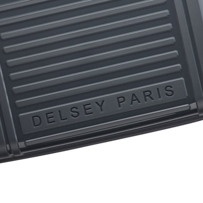 Detalhe da parte frontal cinza escuro de mala de bordo rígida com textura em linhas horizontais e logo DELSEY PARIS em relevo, destacando design e durabilidade.