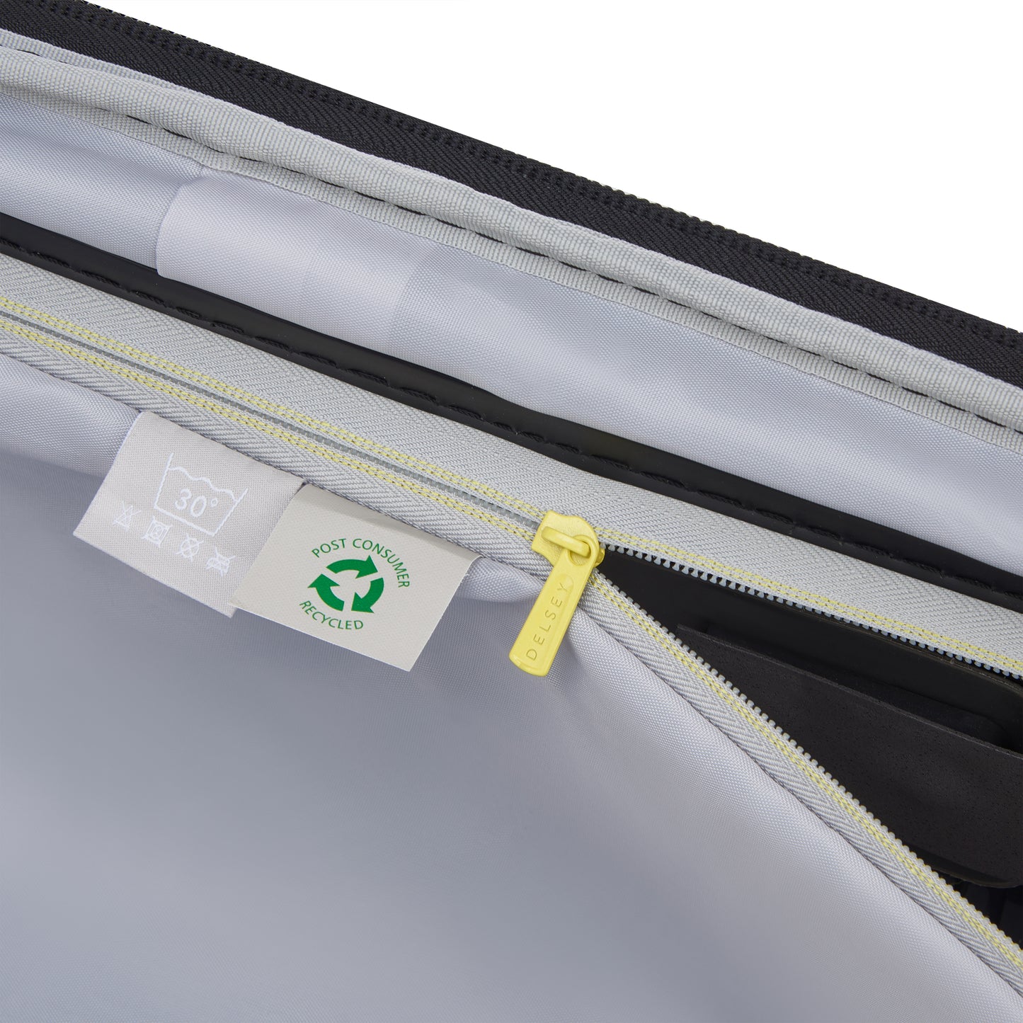 Detalhe interno da mala de bordo DELSEY com zíper amarelo, bolso organizado e etiqueta indicando material reciclado, destacando durabilidade e design premium.