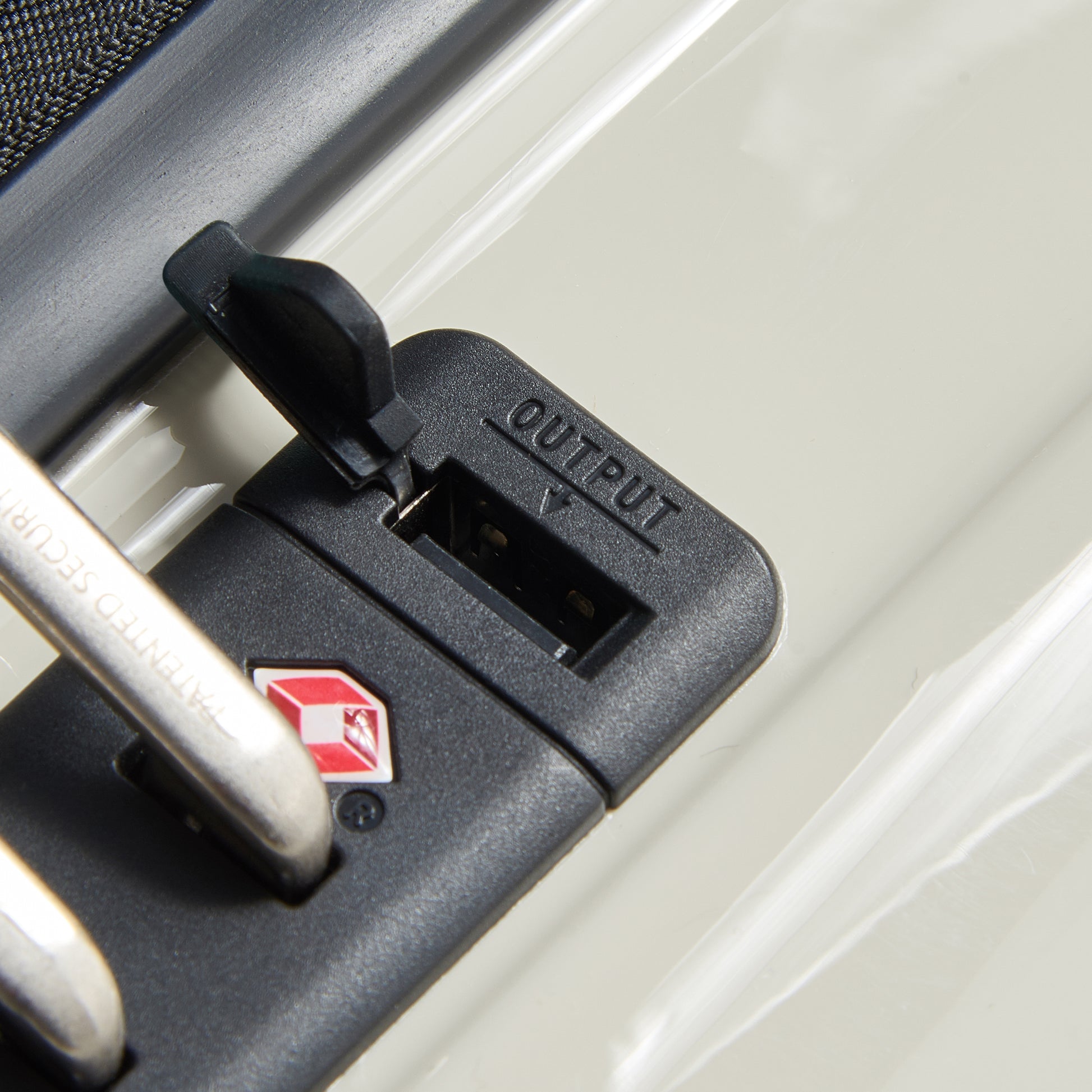 Fechadura TSA integrada em mala de bordo off white da DELSEY, com porta USB para recarga de dispositivos, destacando segurança e funcionalidade para viagens.