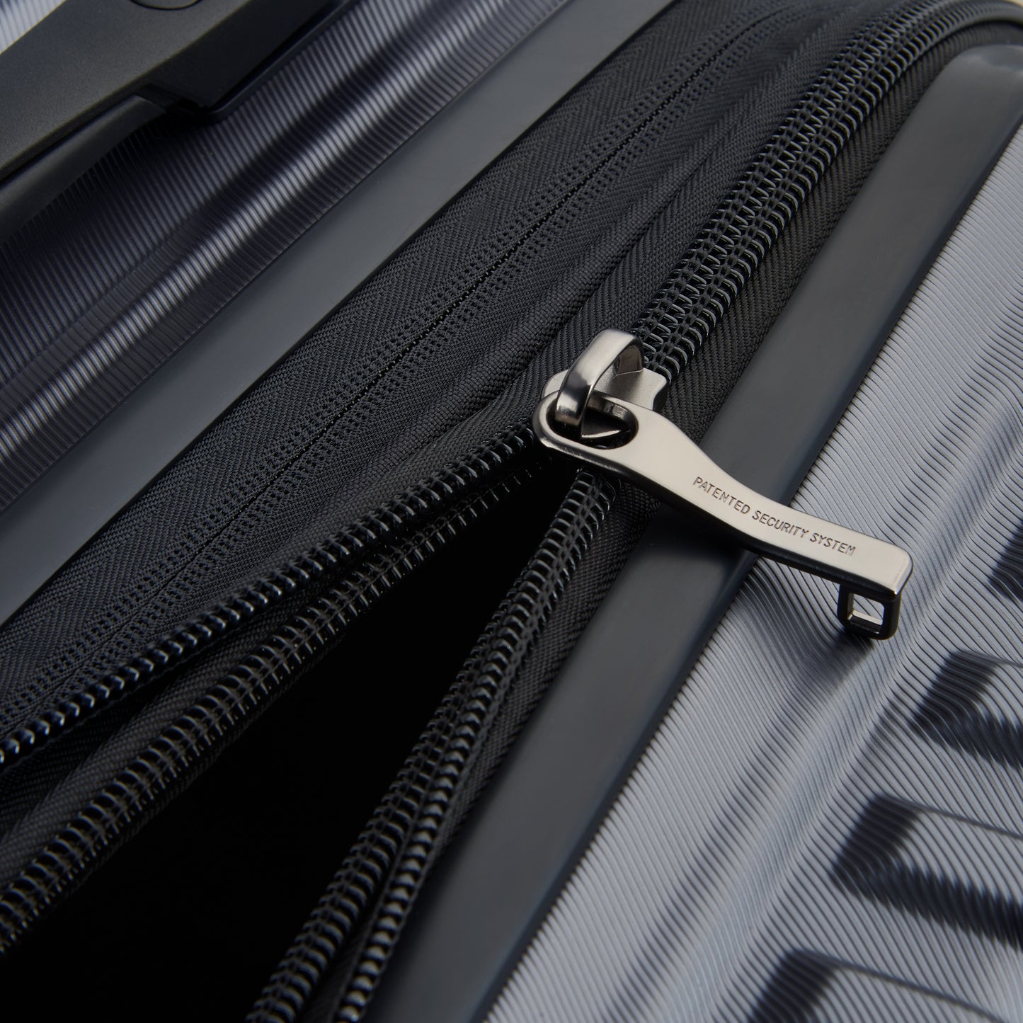 Fechadura com zíper antifurto em mala rígida cinza escuro DELSEY, resistente e expansível, ideal para viagens seguras e duráveis.