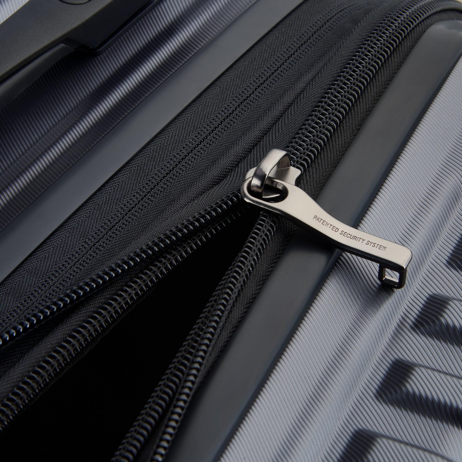 Fechadura com zíper antifurto em mala rígida cinza escuro DELSEY, resistente e expansível, ideal para viagens seguras e duráveis.