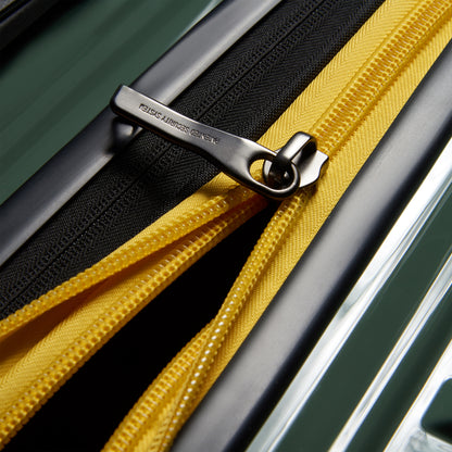 Fechadura metálica de zíper antifurto em mala rígida verde com detalhe amarelo, destacando acabamento premium da DELSEY.