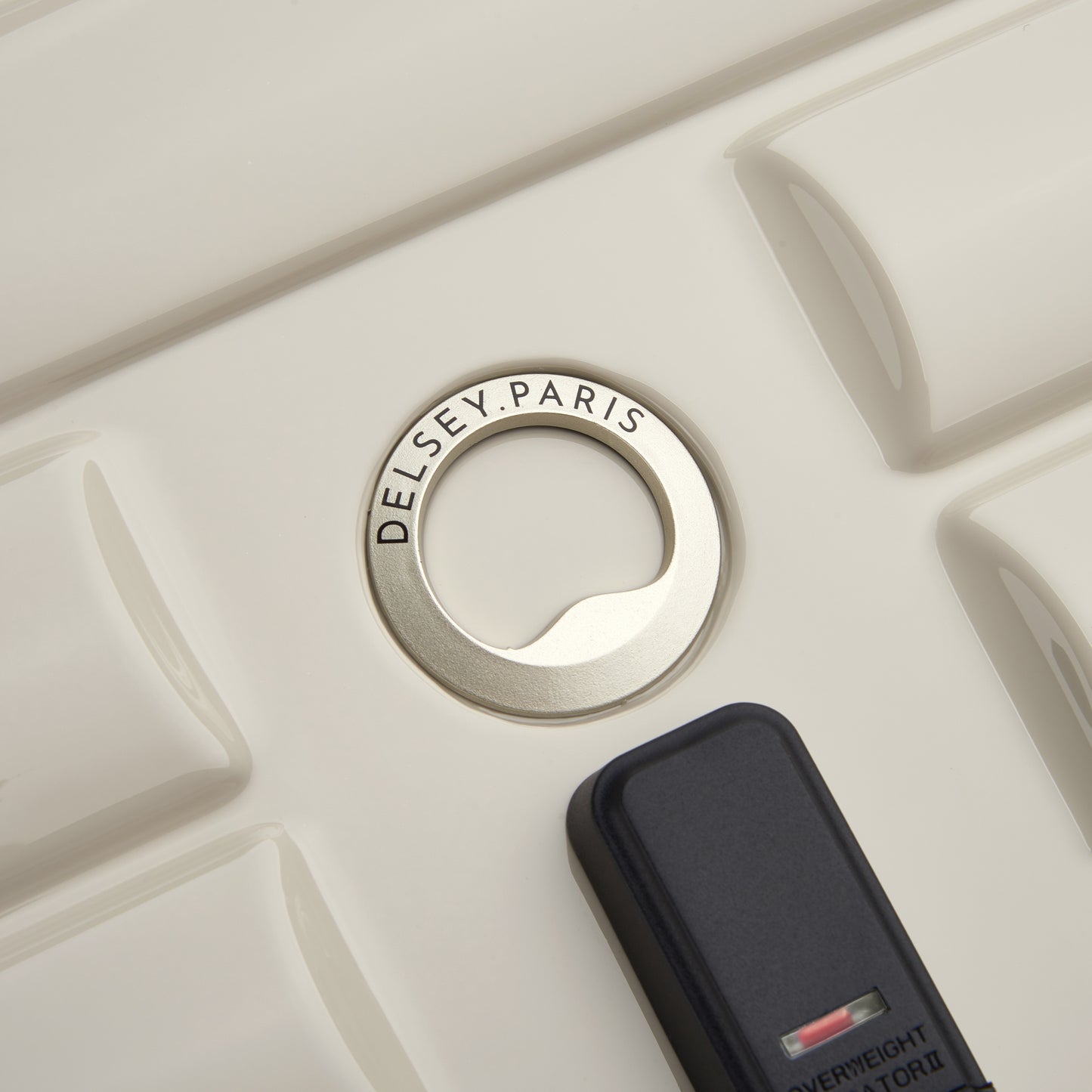 Detalhe do fecho com zíper antifurto em mala rígida off white da DELSEY, destacando o design moderno e qualidade premium da marca francesa.