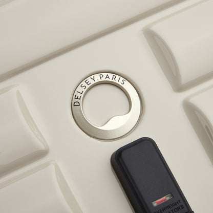 Detalhe do fecho com zíper antifurto em mala rígida off white da DELSEY, destacando o design moderno e qualidade premium da marca francesa.