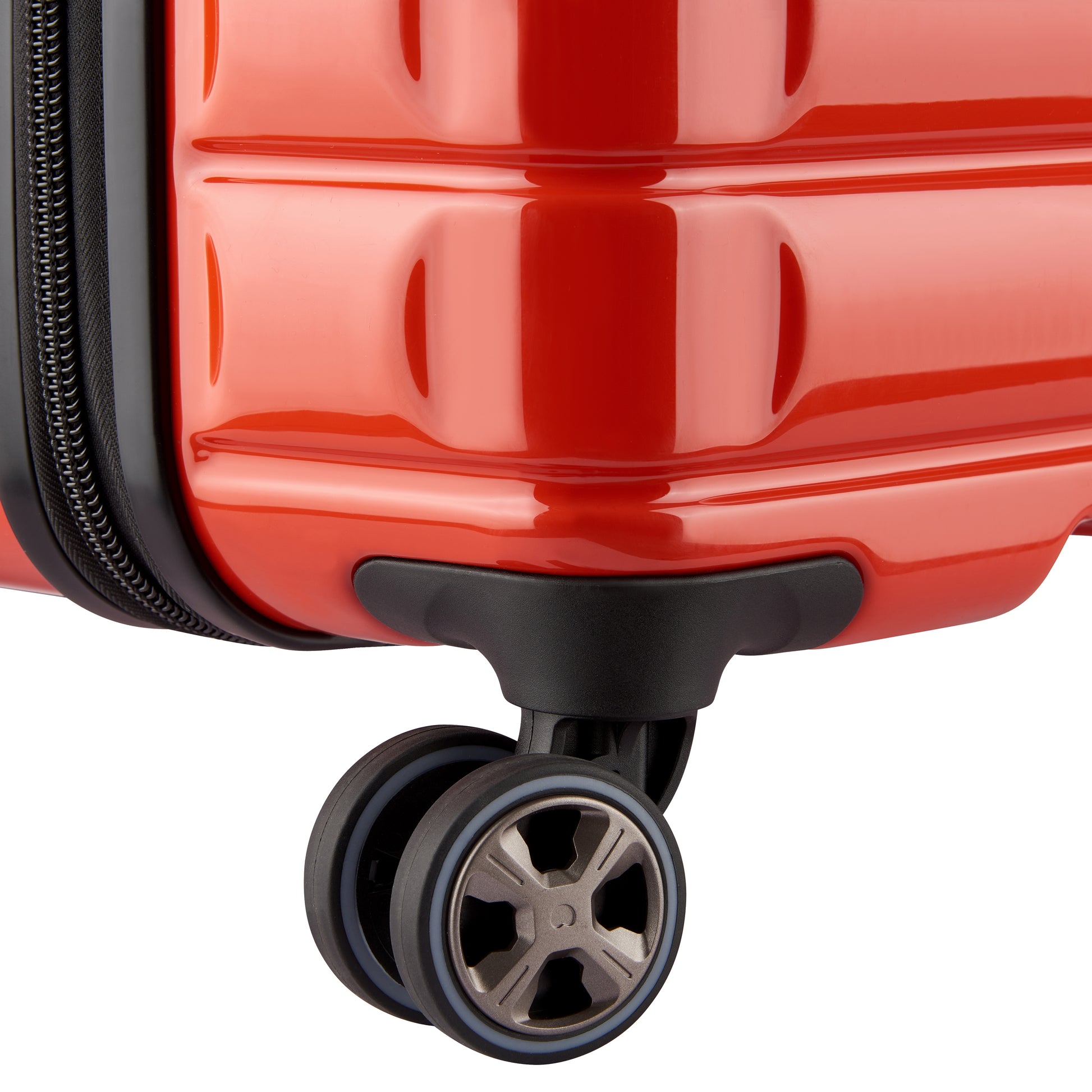 Detalhe da roda dupla giratória e estrutura rígida em policarbonato laranja de mala média DELSEY, ideal para viagens com design resistente e funcionalidade avançada.