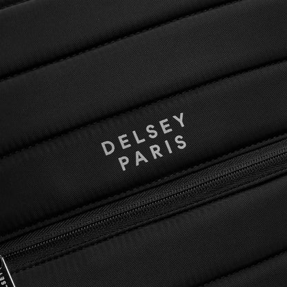 Logo da marca DELSEY Paris em mochila preta com textura acolchoada e zíper, representando acessórios de alta qualidade para notebook e viagem.