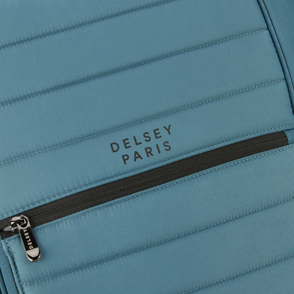 Detalhe em close de mochila DELSEY Paris em tecido resistente azul com zíper preto e costura reforçada, exemplificando qualidade e design premium.